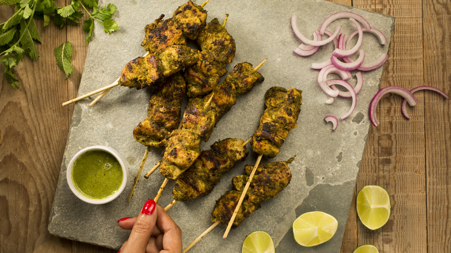 Hariyali chicken tikka kebabs styled with chutney, lime, and red onion